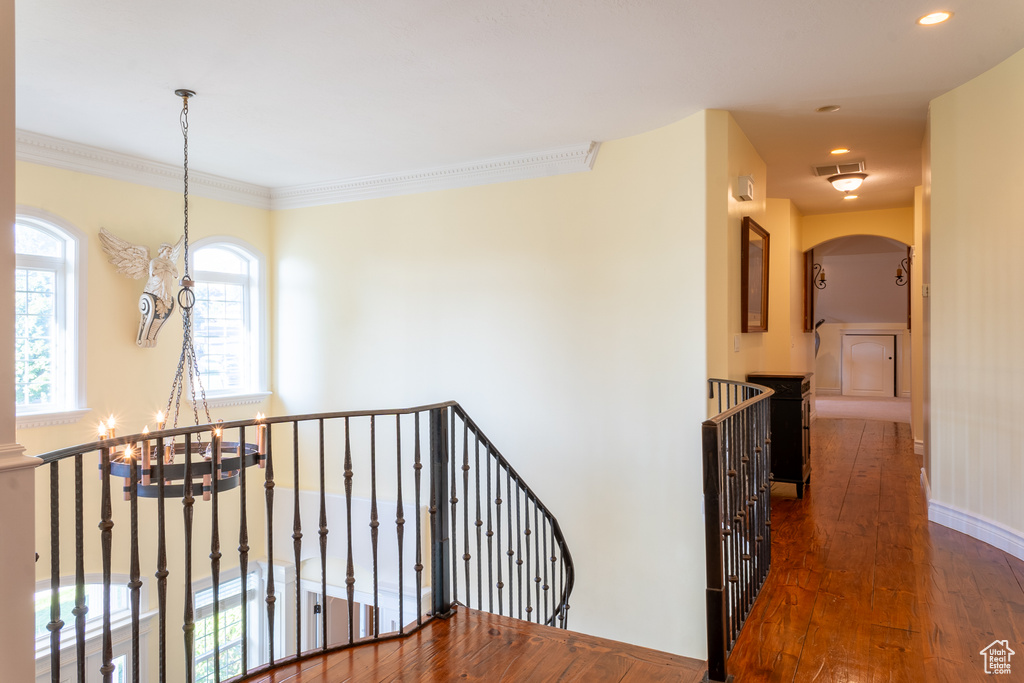 Corridor featuring an upstairs landing, a chandelier, dark wood finished floors, arched walkways, and recessed lighting