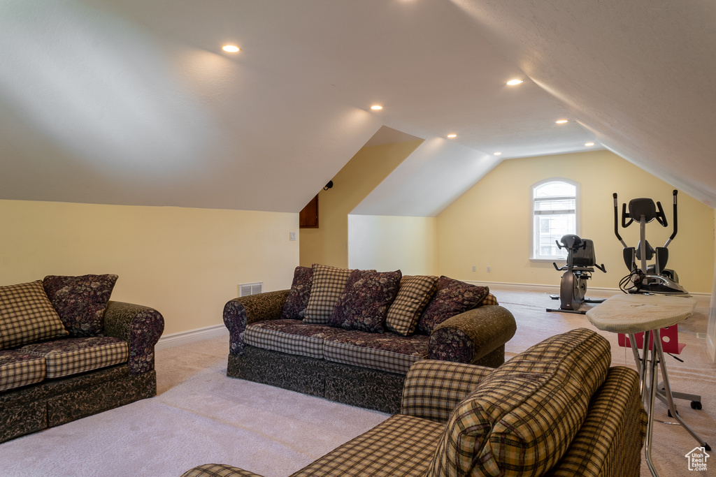 Carpeted living area featuring vaulted ceiling, baseboards, and recessed lighting