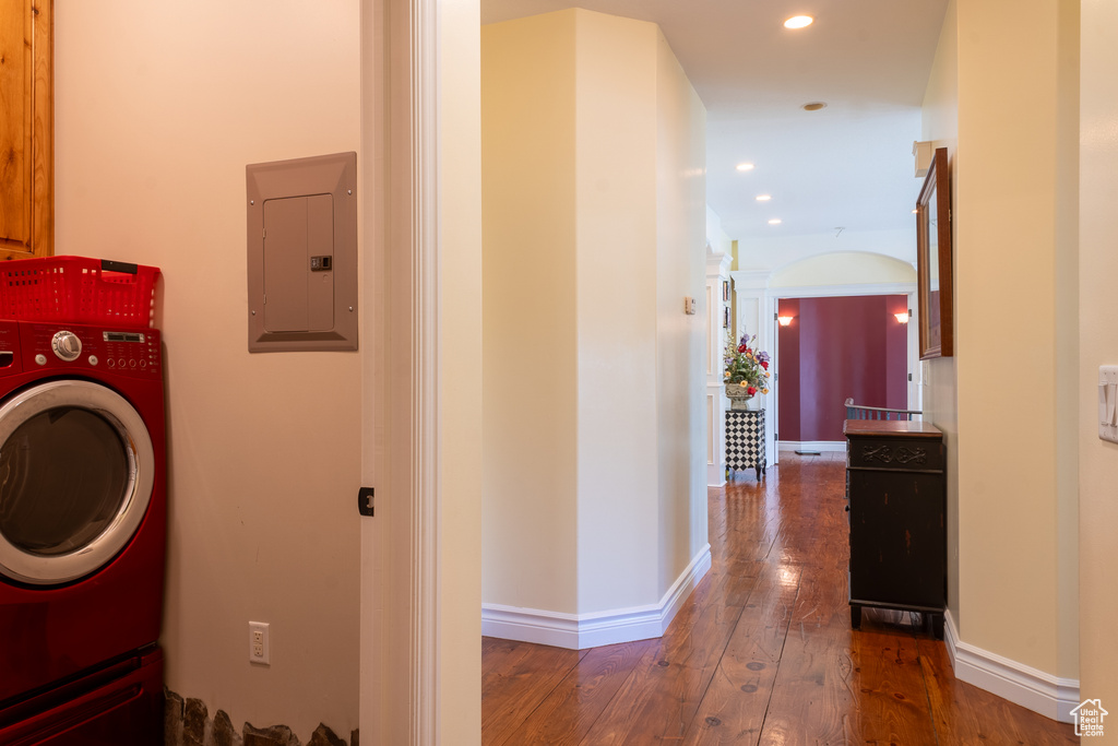 Washroom featuring washer / dryer, electric panel, wood-type flooring, recessed lighting, and baseboards