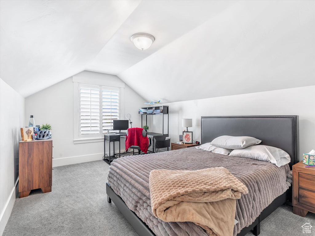 Bedroom featuring carpet, vaulted ceiling, and baseboards
