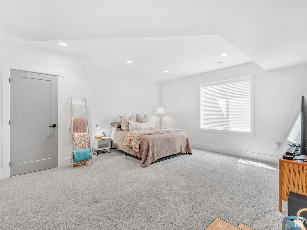 Carpeted bedroom with multiple windows and recessed lighting