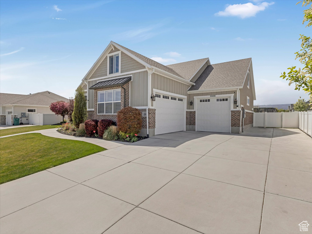 Craftsman house featuring brick siding, concrete driveway, an attached garage, a shingled roof, and board and batten siding
