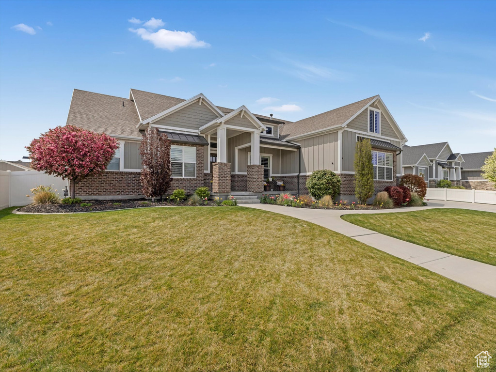 Craftsman inspired home featuring brick siding, board and batten siding, a shingled roof, and a porch