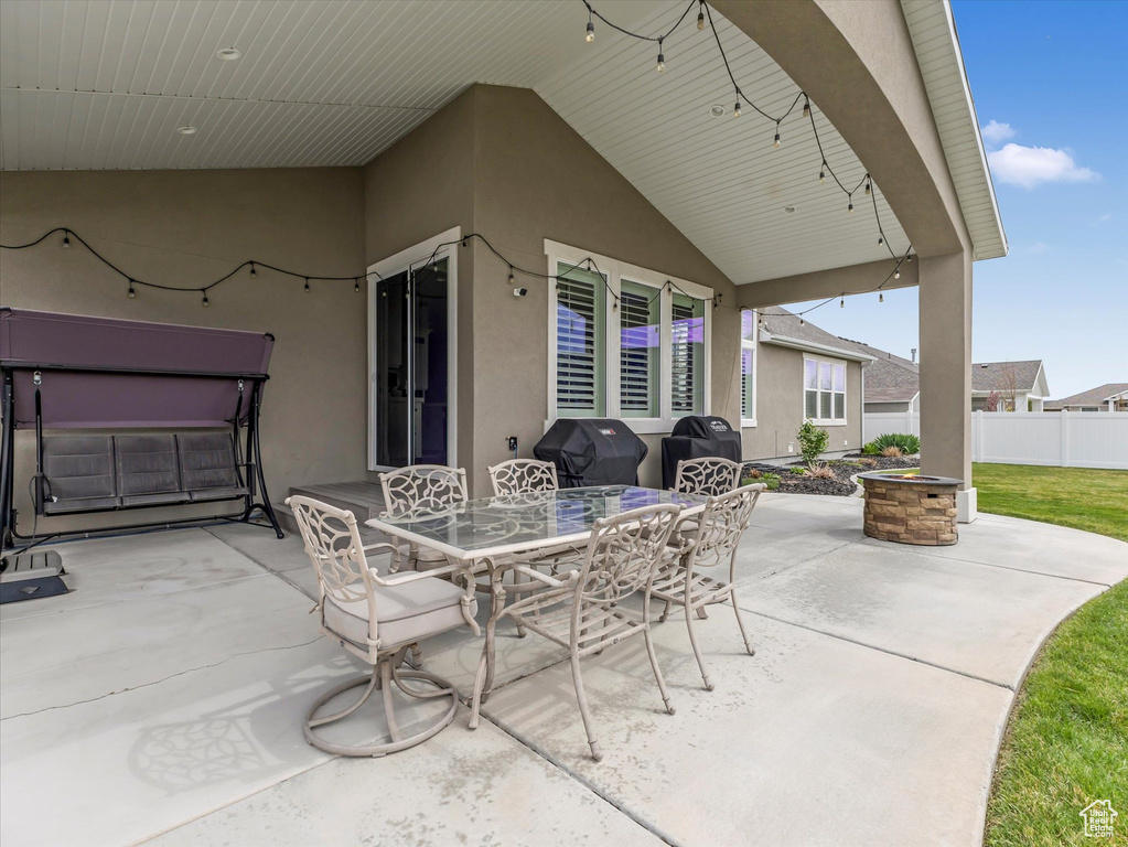 View of patio featuring fence, outdoor dining area, and area for grilling