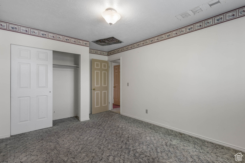 Unfurnished bedroom with carpet floors, a closet, and baseboards