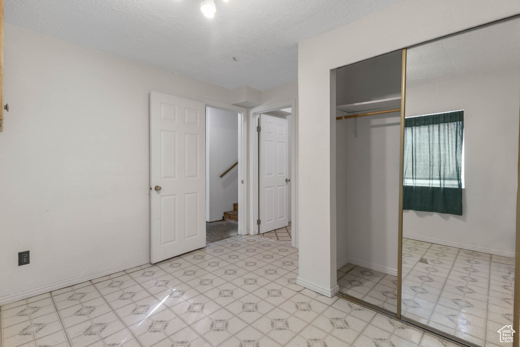 Unfurnished bedroom with a closet and a textured ceiling