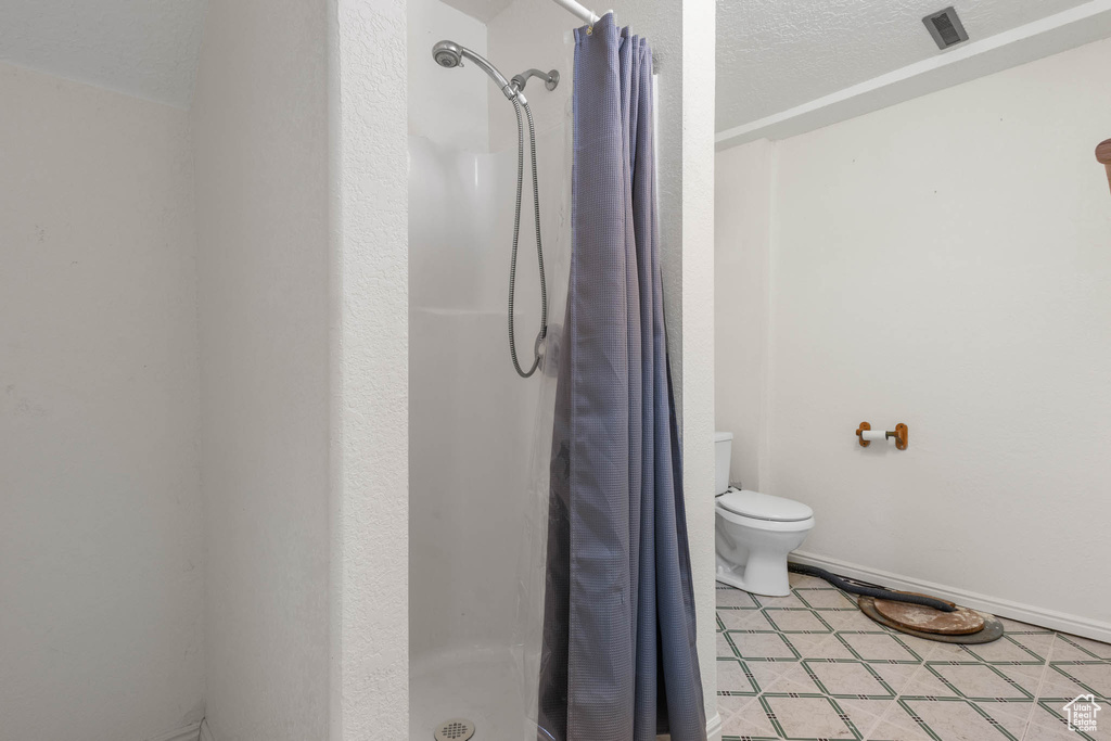 Bathroom with a shower stall and toilet