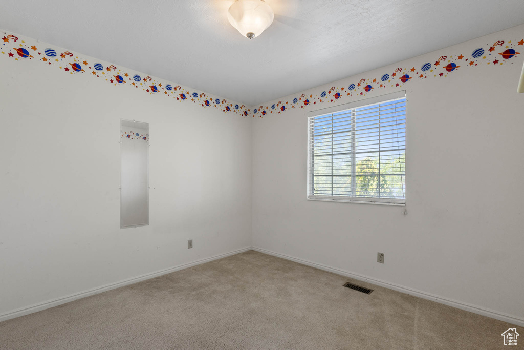 Empty room featuring light colored carpet and baseboards