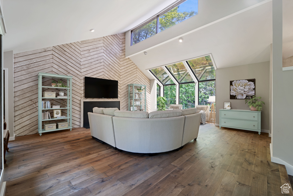 Living room featuring an accent wall, hardwood / wood-style flooring, and baseboards