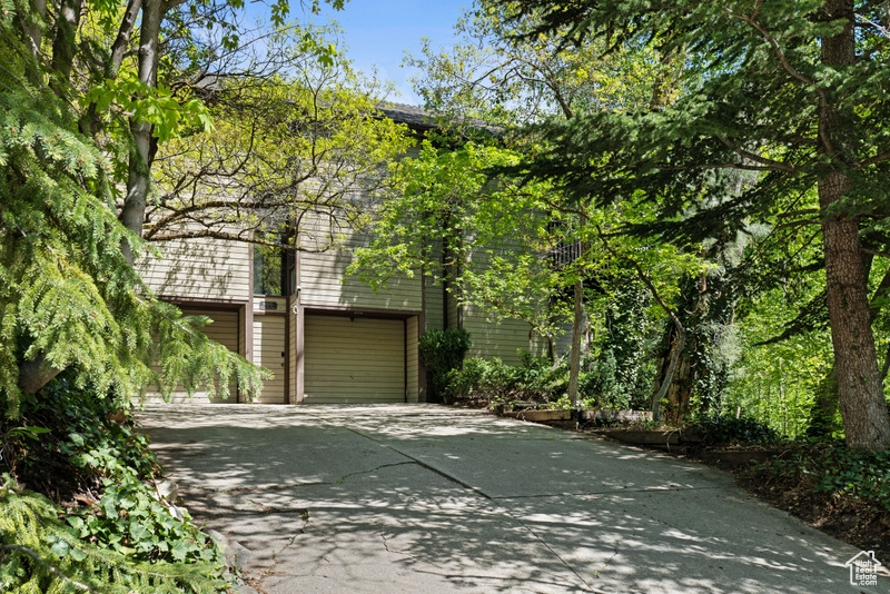 View of side of home featuring concrete driveway and a garage