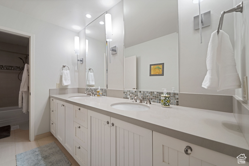 Bathroom featuring double vanity, tile patterned floors, and recessed lighting