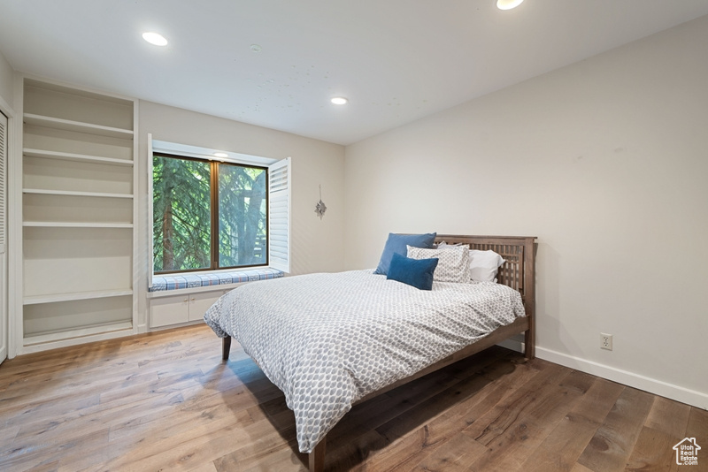 Bedroom with light wood-style flooring, recessed lighting, and baseboards