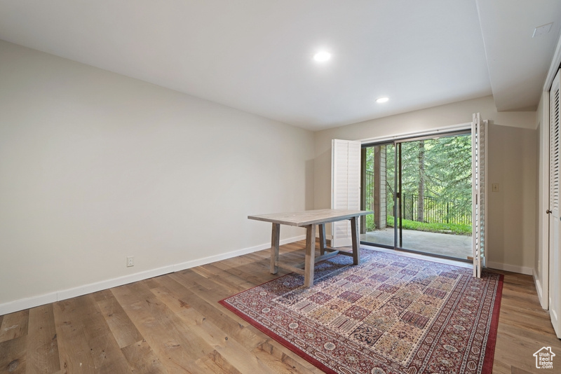 Unfurnished office with baseboards, wood finished floors, and recessed lighting