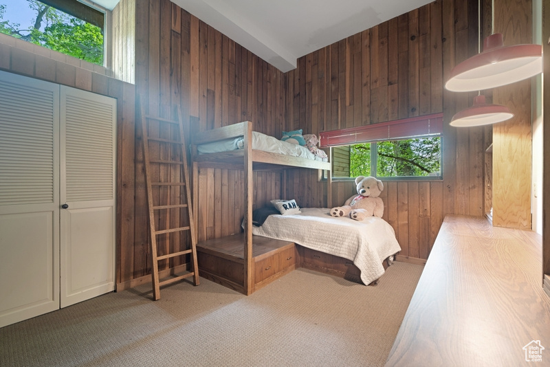 Bedroom featuring wood walls and carpet flooring