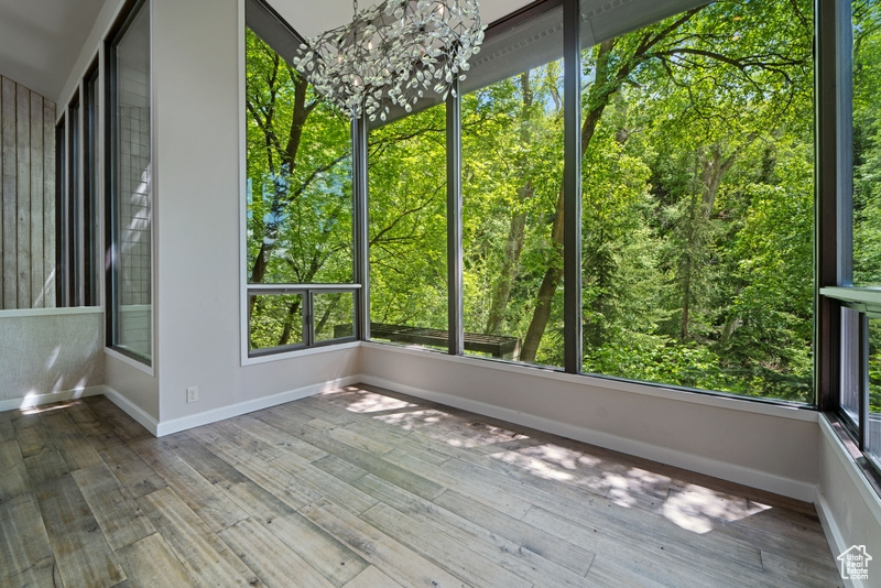 Unfurnished sunroom featuring a chandelier