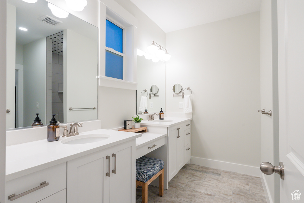 Bathroom featuring two vanities, baseboards, and recessed lighting