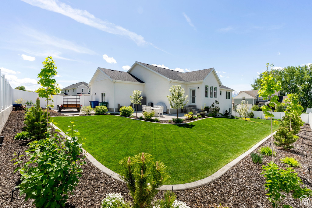 Back of house with a patio area and stucco siding