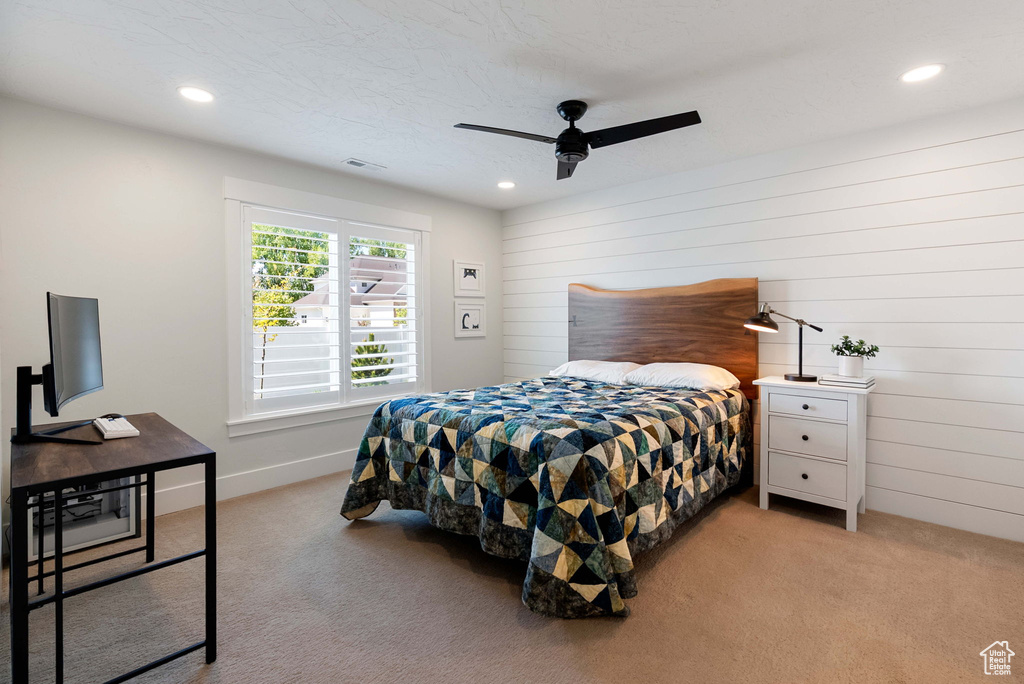 Bedroom featuring light colored carpet, recessed lighting, wood walls, ceiling fan, and baseboards
