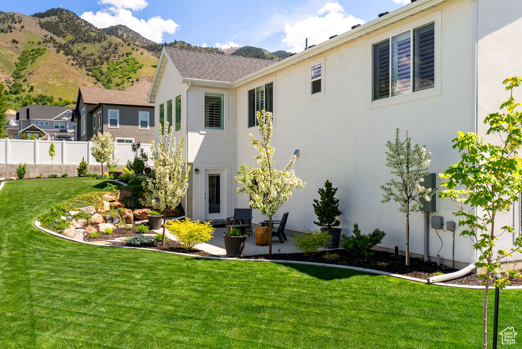 Back of property featuring stucco siding, a patio, and a mountain view