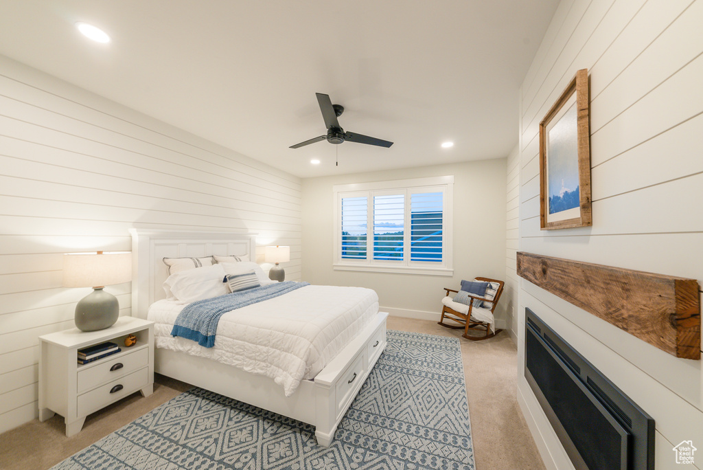 Bedroom featuring wooden walls, light carpet, recessed lighting, and a ceiling fan