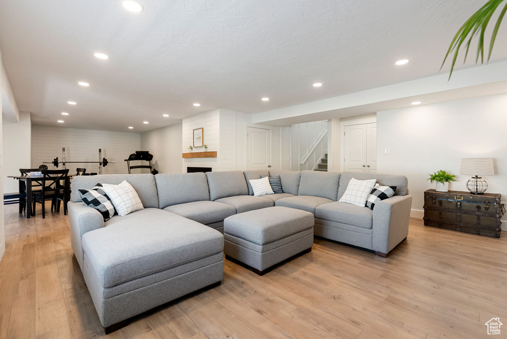 Living room featuring stairs, light wood-type flooring, and recessed lighting
