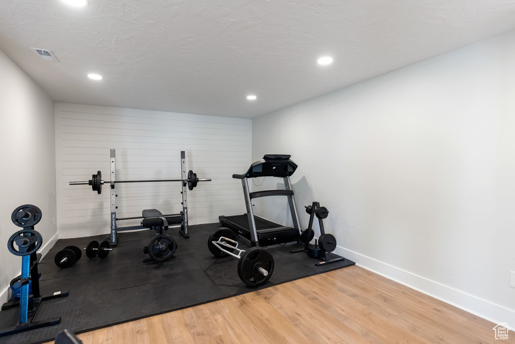 Workout area with wood finished floors, baseboards, and recessed lighting