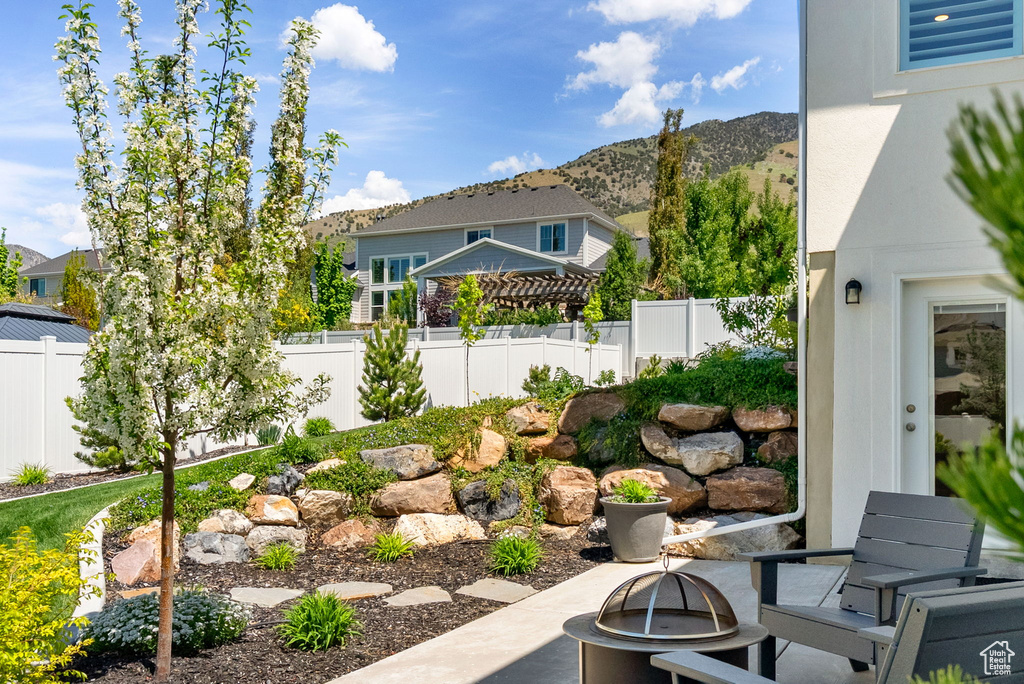 Fenced yard with an outdoor fire pit, a mountain view, and a patio area