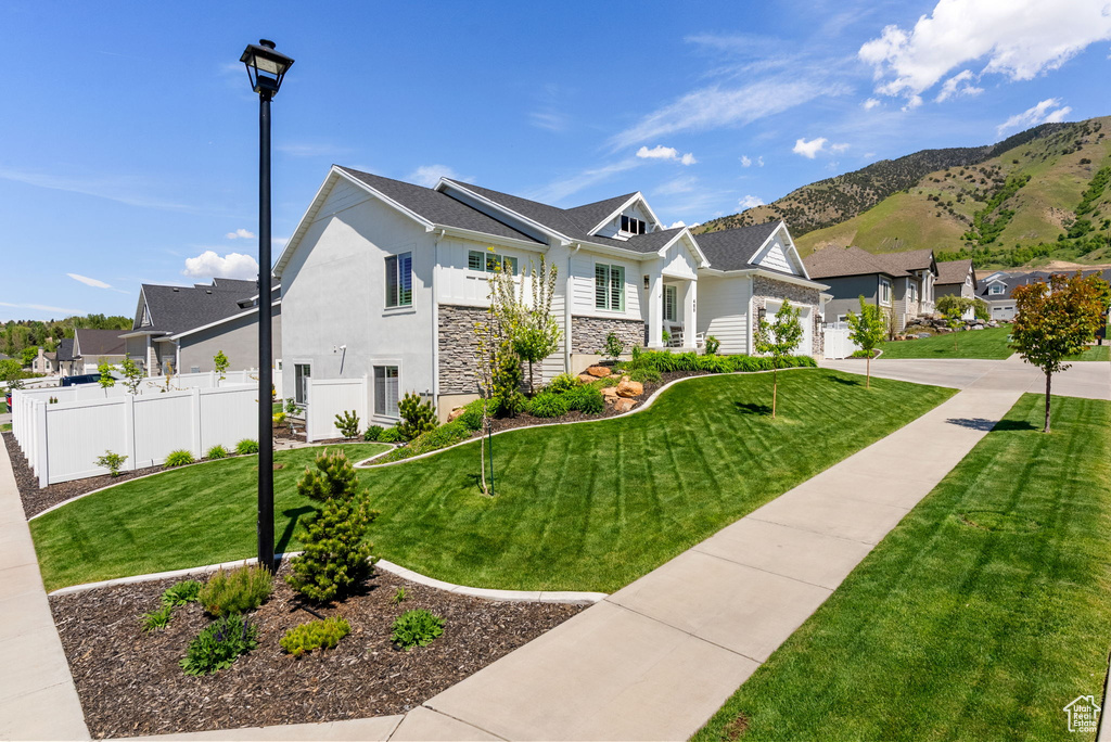 View of front of house with stone siding, a residential view, a mountain view, and stucco siding