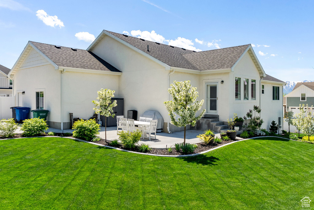 Rear view of house with a patio, stucco siding, roof with shingles, and entry steps