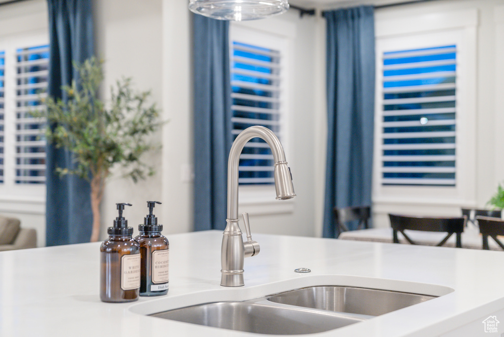Kitchen view of a sink and light countertops