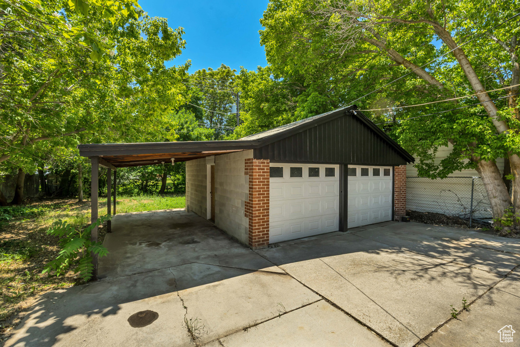 Garage featuring a detached garage and view of scattered trees