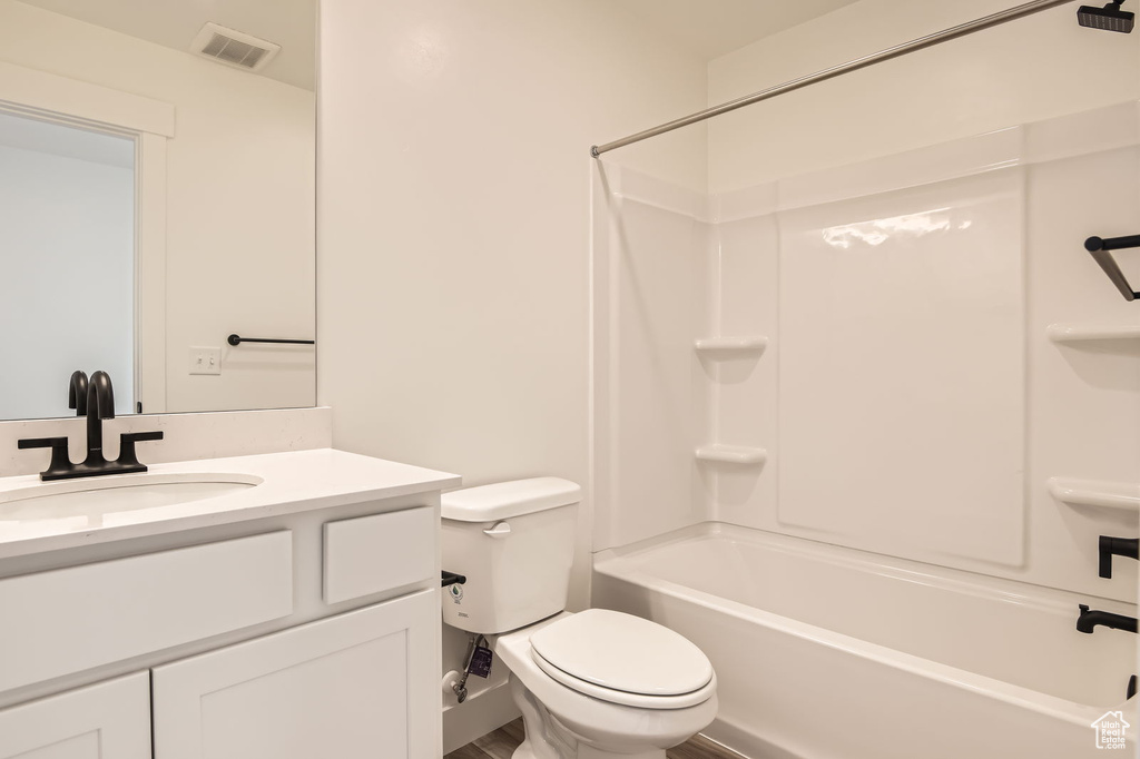 Bathroom featuring toilet, vanity, and bathing tub / shower combination