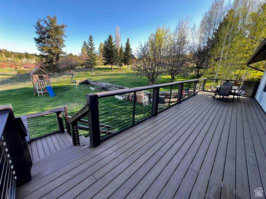 Deck with a playground and a yard