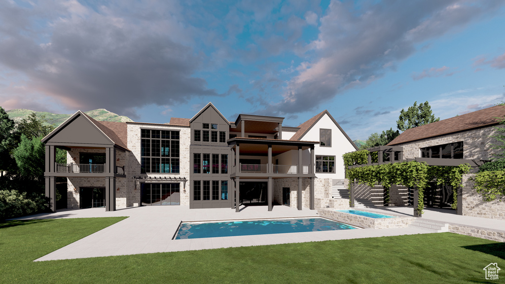 Back of property featuring a balcony, a patio area, a lawn, and an outdoor pool