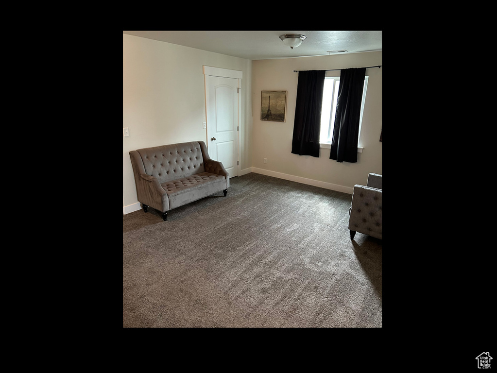 Living area featuring baseboards and carpet floors