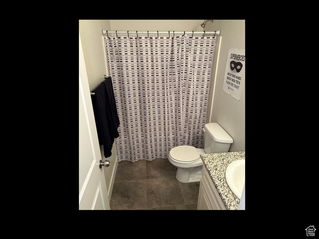 Bathroom with vanity, toilet, and tile patterned flooring