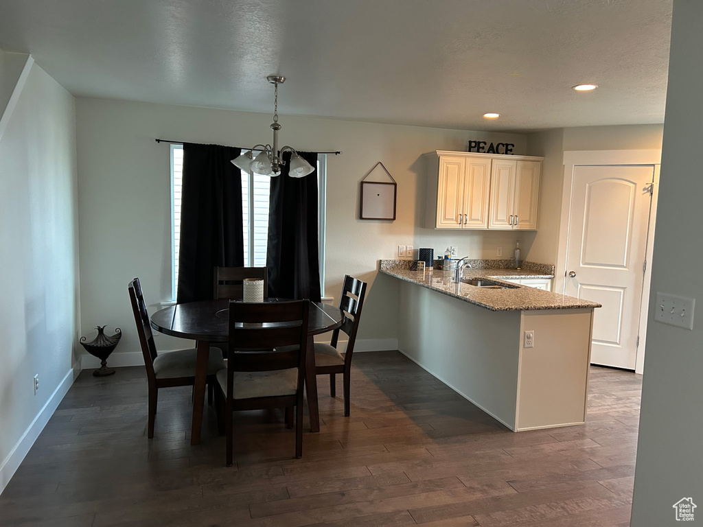 Dining room with a chandelier, baseboards, recessed lighting, and dark wood-style floors