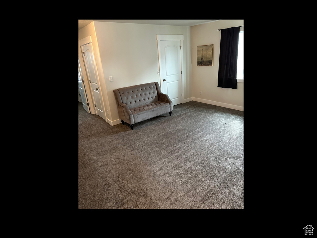 Sitting room featuring baseboards and carpet