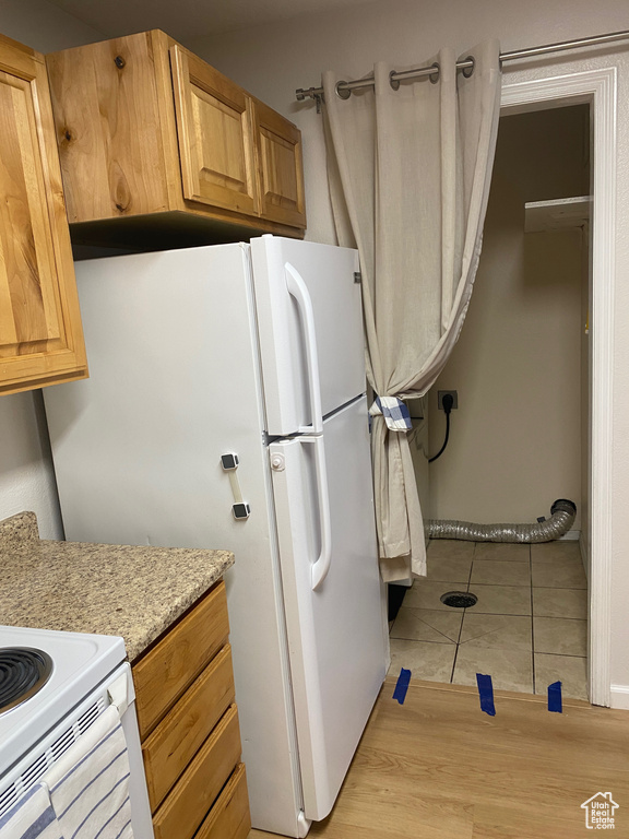 Kitchen with freestanding refrigerator and light tile patterned flooring
