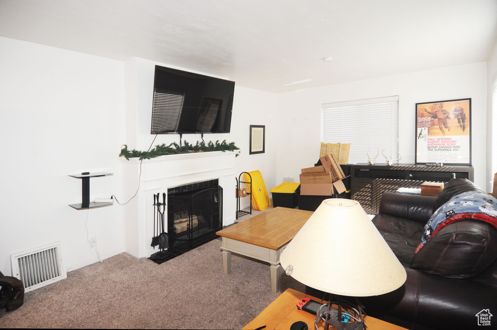 Carpeted living room featuring a fireplace with flush hearth