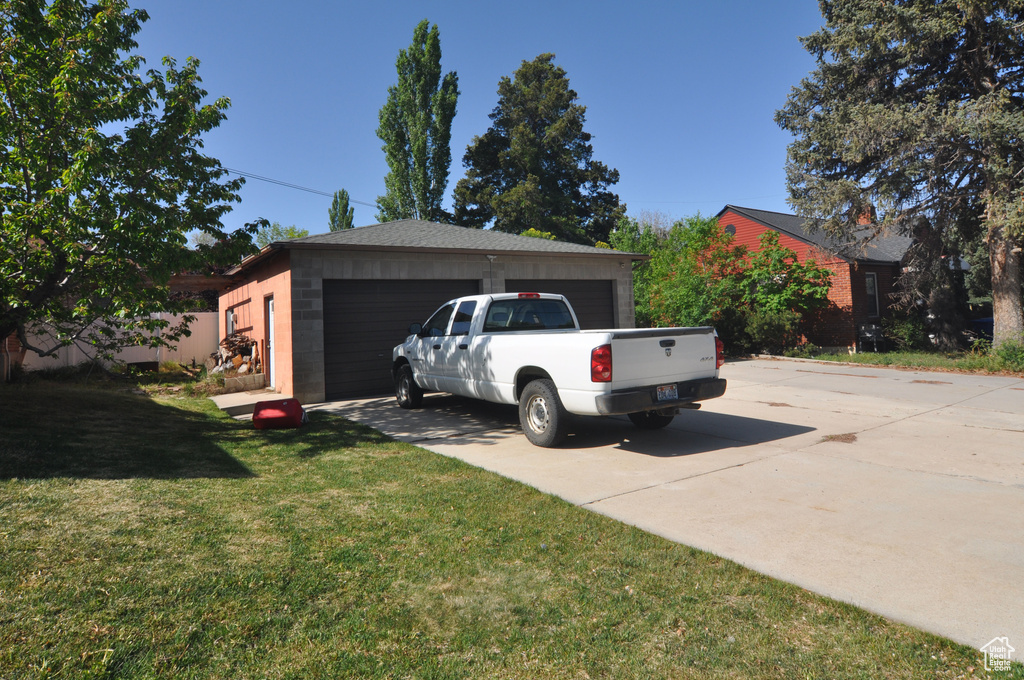 View of front facade with a front lawn, an outdoor structure, and a garage
