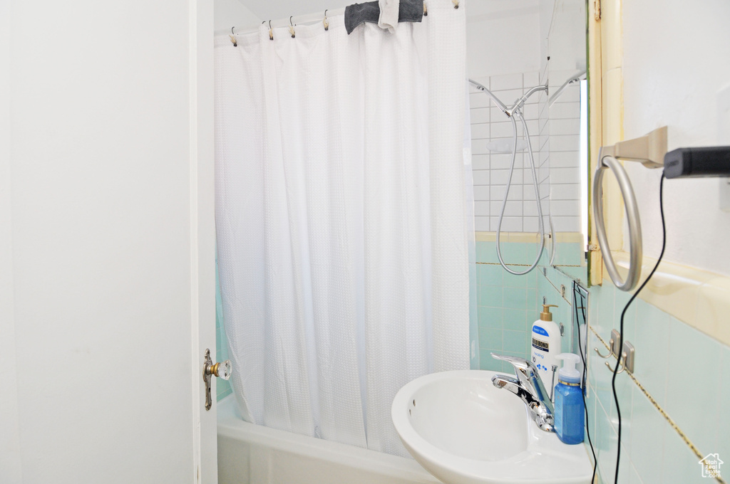 Full bathroom with a sink and shower / bath combo with shower curtain