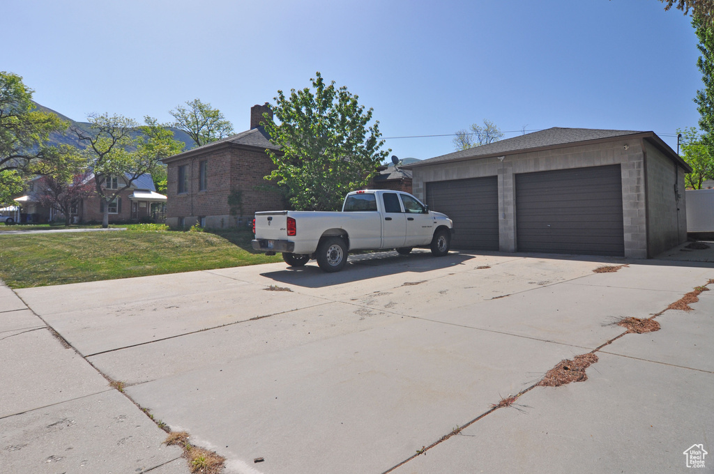 View of property exterior with a garage and a yard