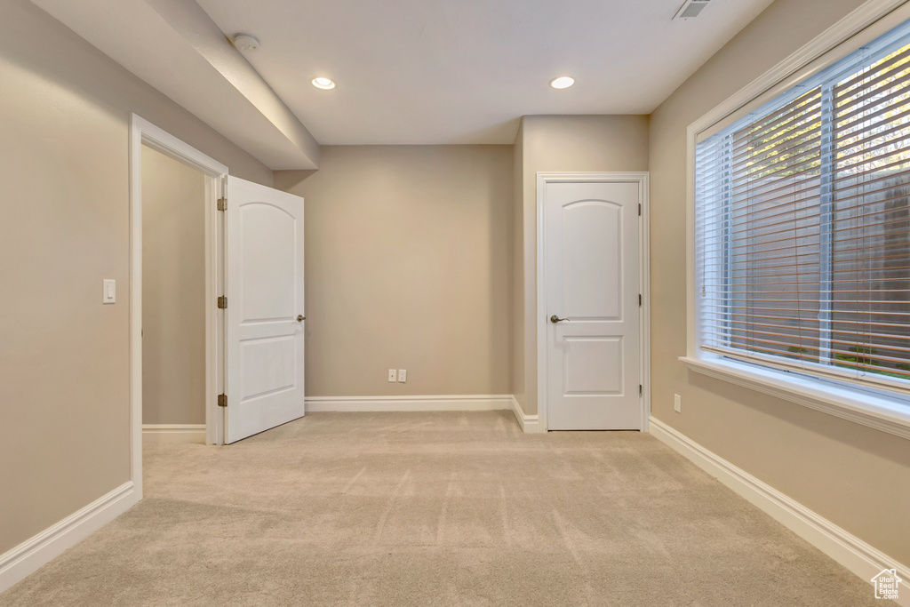 Unfurnished room with light colored carpet, recessed lighting, baseboards, and a smoke detector