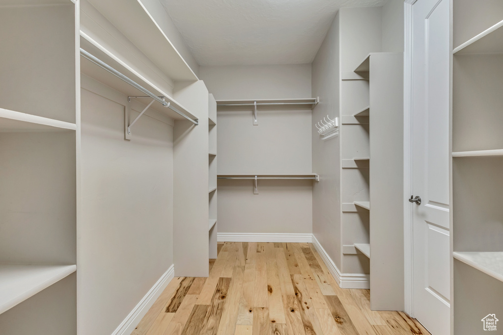 Walk in closet with light wood-type flooring