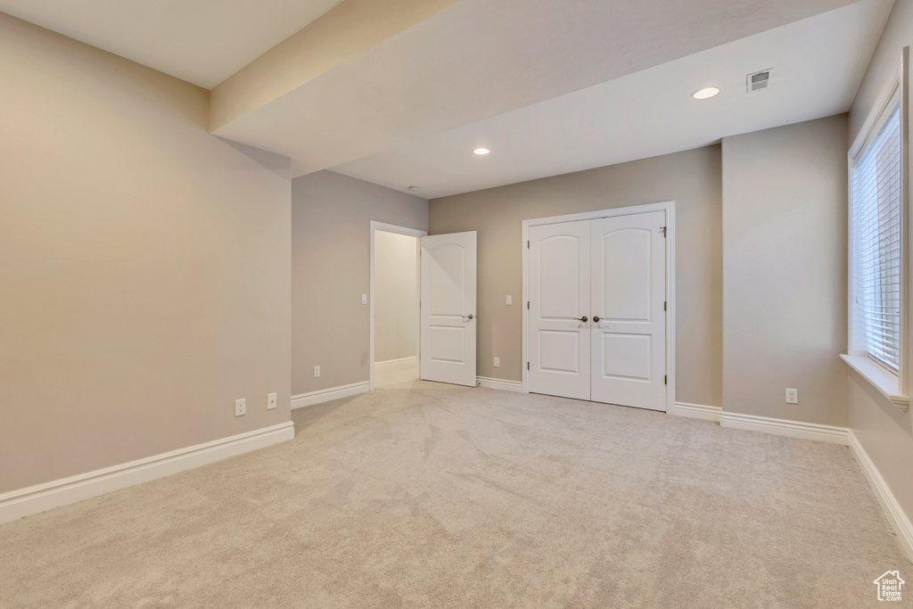 Unfurnished bedroom with baseboards, light colored carpet, recessed lighting, and a closet