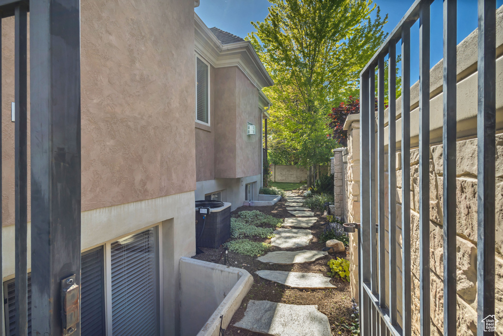 View of side of property featuring central air condition unit and stucco siding