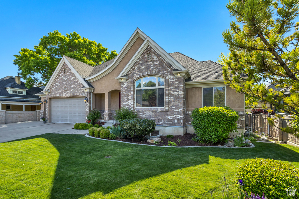 View of front of house with brick siding, driveway, and an attached garage