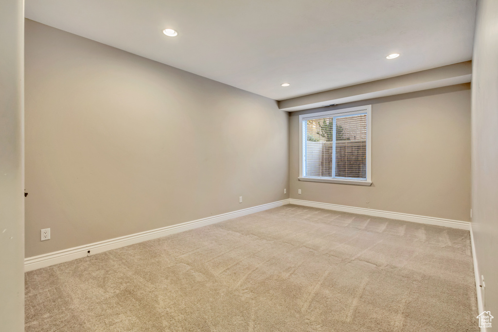 Carpeted spare room with baseboards and recessed lighting