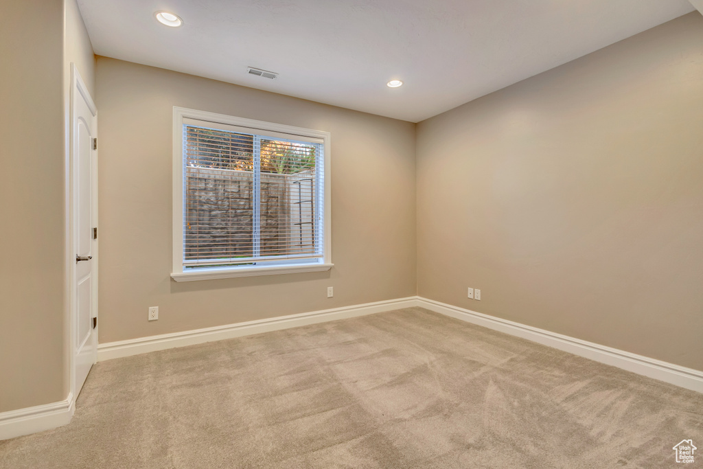 Carpeted empty room with baseboards and recessed lighting